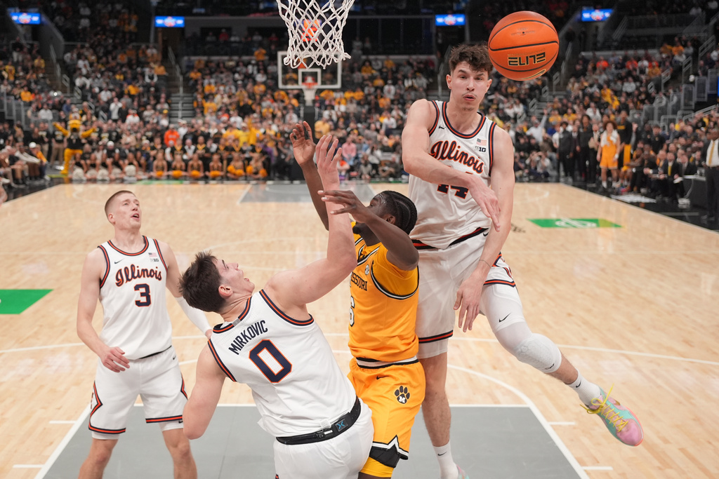 Illinois' Zvonimir Ivisic, right, knocks away a shot from Missouri's Annor Boateng (6) as Illinois' David Mirkovic (0) and Ben Humrichous (3) watch during the first half of an NCAA college basketball game Monday, Dec. 22, 2025, in St. Louis. (AP Photo/Jeff Roberson)