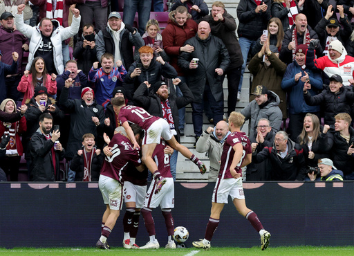 Heart of Midlothian's Lawrence Shankland, obscured, is mobbed by his teammates after scoring his side's third goal during the Scottish Premiership soccer match between Heart of Midlothian and Celtic, in Edinburgh, Sunday, Oct. 26, 2025. (Steve Welsh/PA via AP) Heart of Midlothian's Lawrence Shankland, obscured, is mobbed by his teammates after scoring his side's third goal during the Scottish Premiership soccer match between Heart of Midlothian and Celtic, in Edinburgh, Sunday, Oct. 26, 2025. (Steve Welsh/PA via AP)
