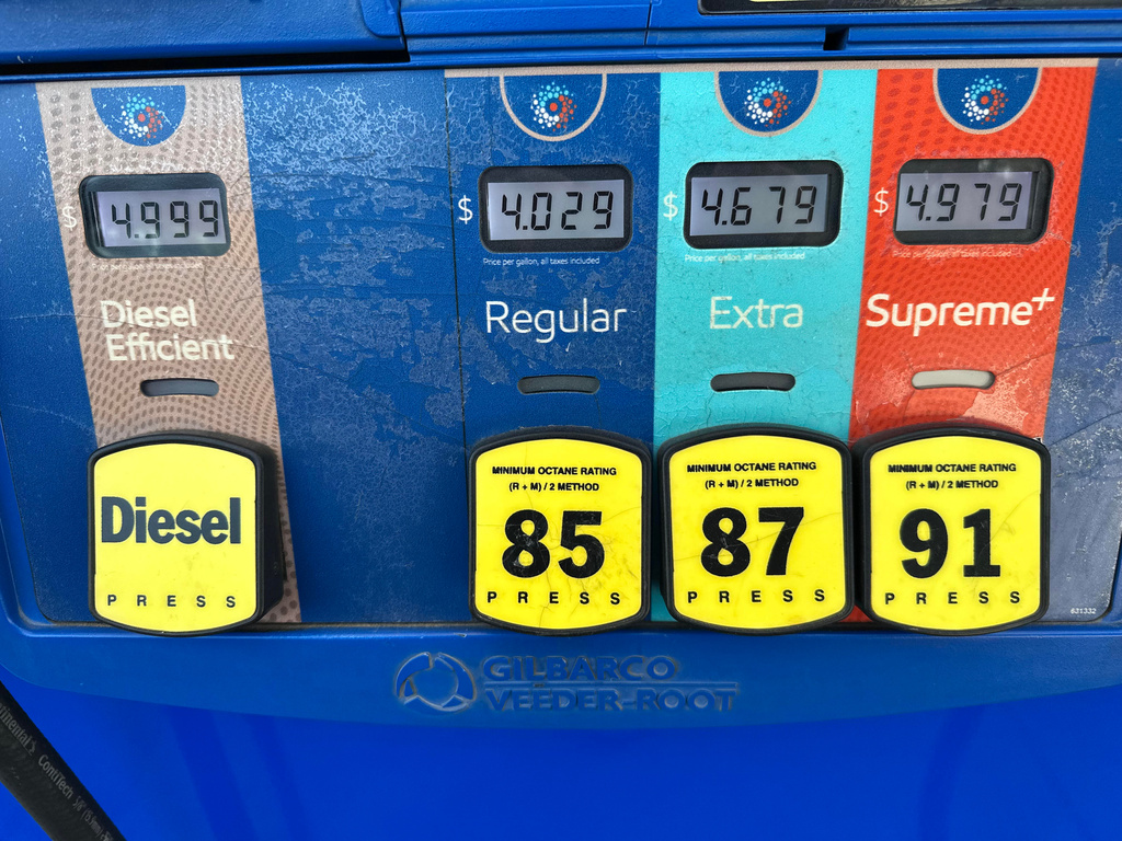 The per-gallon price is displayed electronically above the grades of gasoline available from a pump at an Exxon gasoline station in Litttleton, Colo., Tuesday, May 12, 2026. (AP Photo/David Zalubowski)