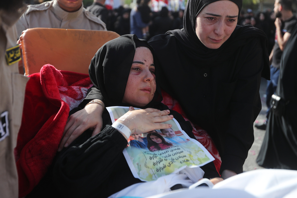 Carried on a stretcher, Amani Bazzi, mourns her husband Shadi Charara and three children, killed Sunday in an Israeli drone strike that hit their car, during the funeral procession in Bint Jbeil, southern Lebanon, Tuesday, Sept. 23, 2025. (AP Photo/Mohammed Zaatari)