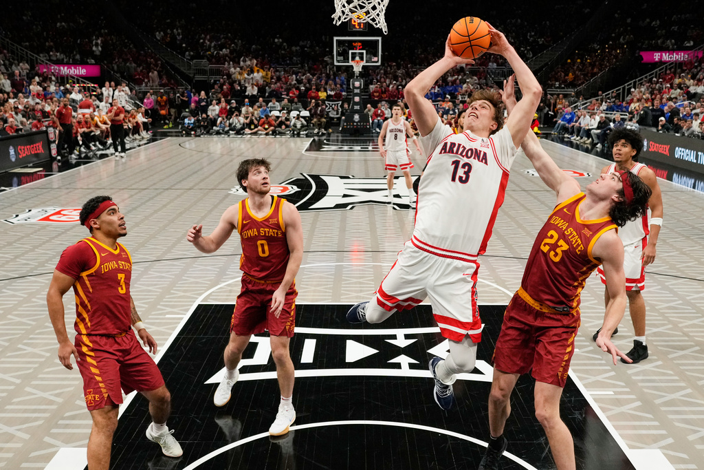 Arizona center Motiejus Krivas (13) gets past Iowa State forward Blake Buchanan (23) to put up a shot during the second half of an NCAA college basketball game in the semifinal round of the Big 12 Conference tournament Friday, March 13, 2026, in Kansas City, Mo. (AP Photo/Charlie Riedel)