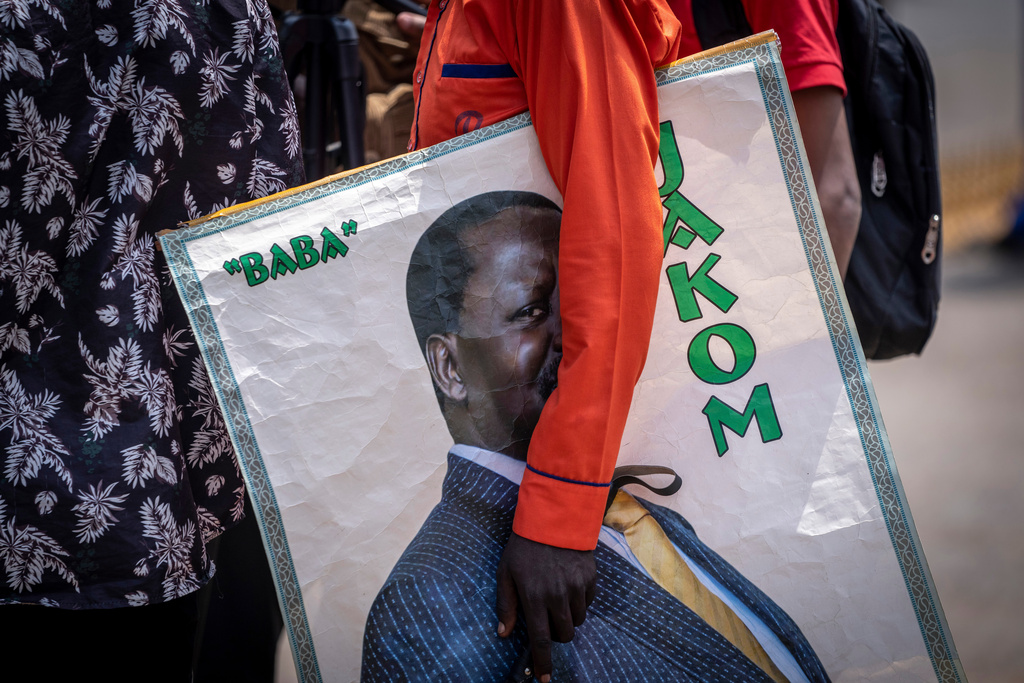 A supporter of presidential candidate Raila Odinga holds a poster of him outside the Supreme Court in Nairobi, Kenya Monday, Aug. 22, 2022. (AP Photo/Ben Curtis)