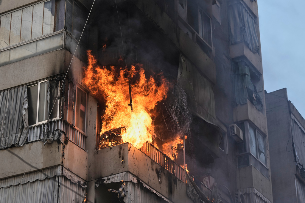 Smoke and flame rise from a residential building following an Israeli airstrike in central Beirut, Lebanon, Wednesday, March 18, 2026. (AP Photo/Bilal Hussein)