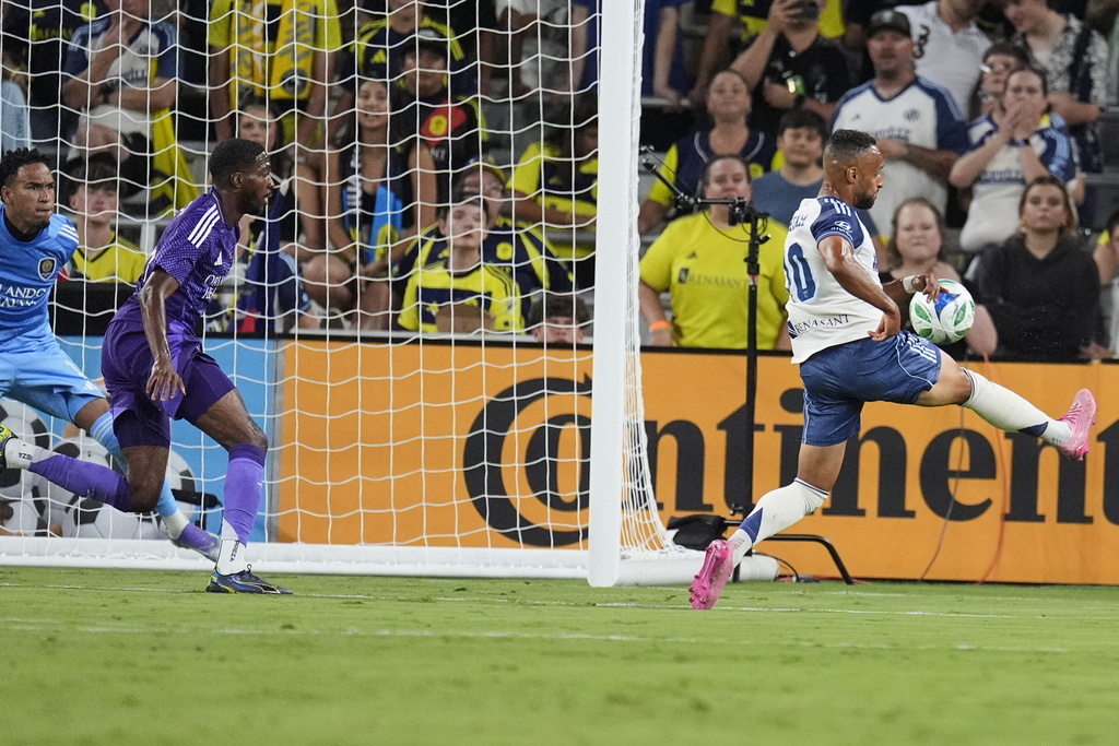 Nashville SC midfielder Hany Mukhtar, right, scores a goal against Orlando City during the first half of an MLS soccer match Saturday, Aug. 23, 2025, in Nashville, Tenn. (AP Photo/George Walker IV)