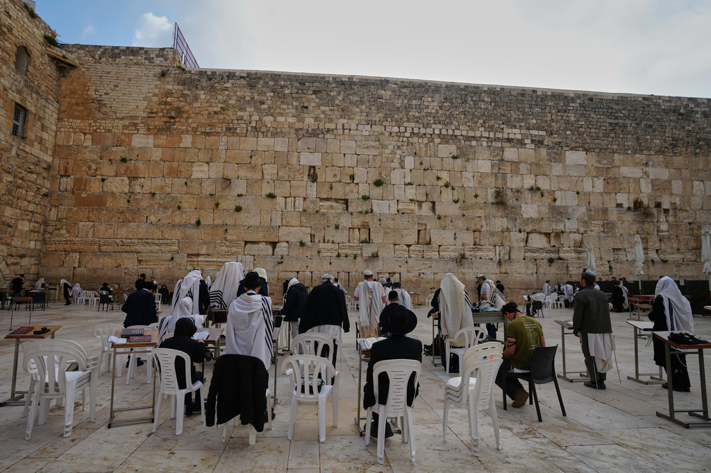 Ultra-Orthodox Jewish men pray at the Western Wall, the holiest site where Jews can pray, after restrictions were lifted following a ceasefire reached between Iran, Israel and the United States, in the Old City of Jerusalem, Thursday, April 9, 2026. (AP Photo/Mahmoud Illean)