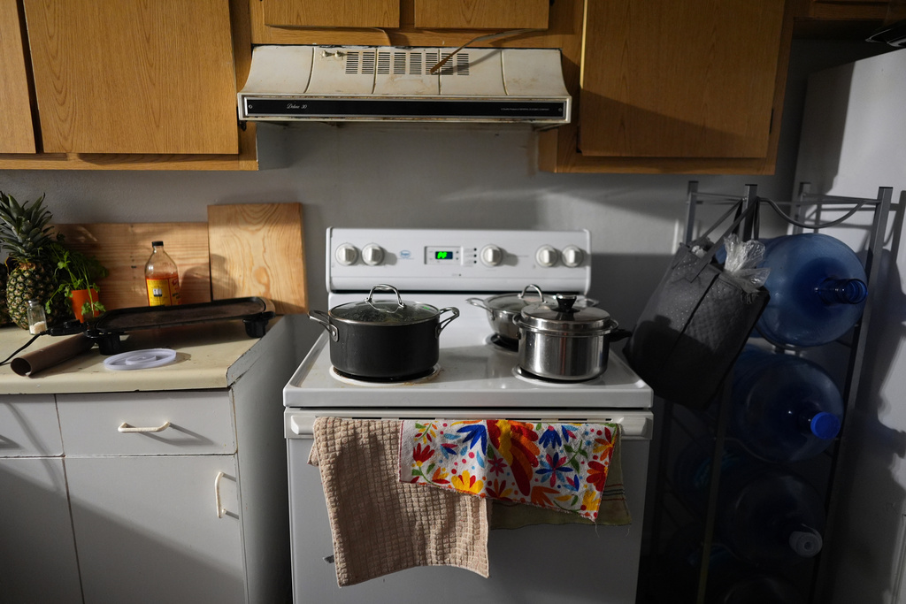 Pots containing food cooked for the family sit on top of the stove in the home of Mexican asylum seeker Blanca, Wednesday, Aug. 20, 2025, in Apopka, Fla. (AP Photo/Rebecca Blackwell)