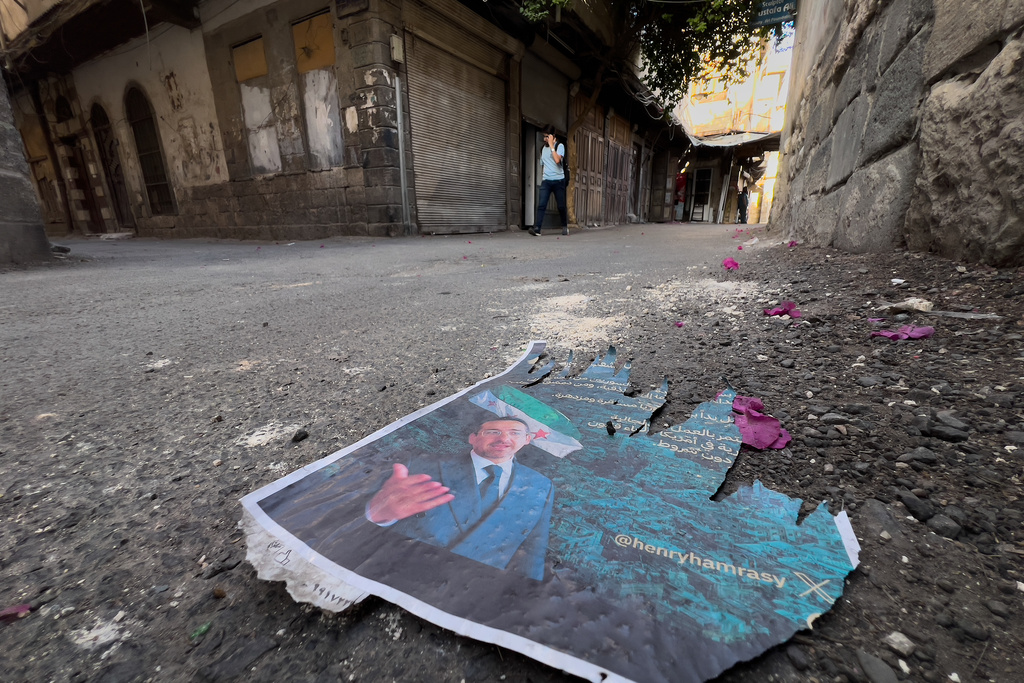 A torn poster of Syrian-American Jew Henry Hamra, a candidate for the Syrian parliamentary elections, lies on the ground at the Jewish neighborhood in old Damascus, Syria, Friday, Oct. 3, 2025. (AP Photo/Hussein Malla)