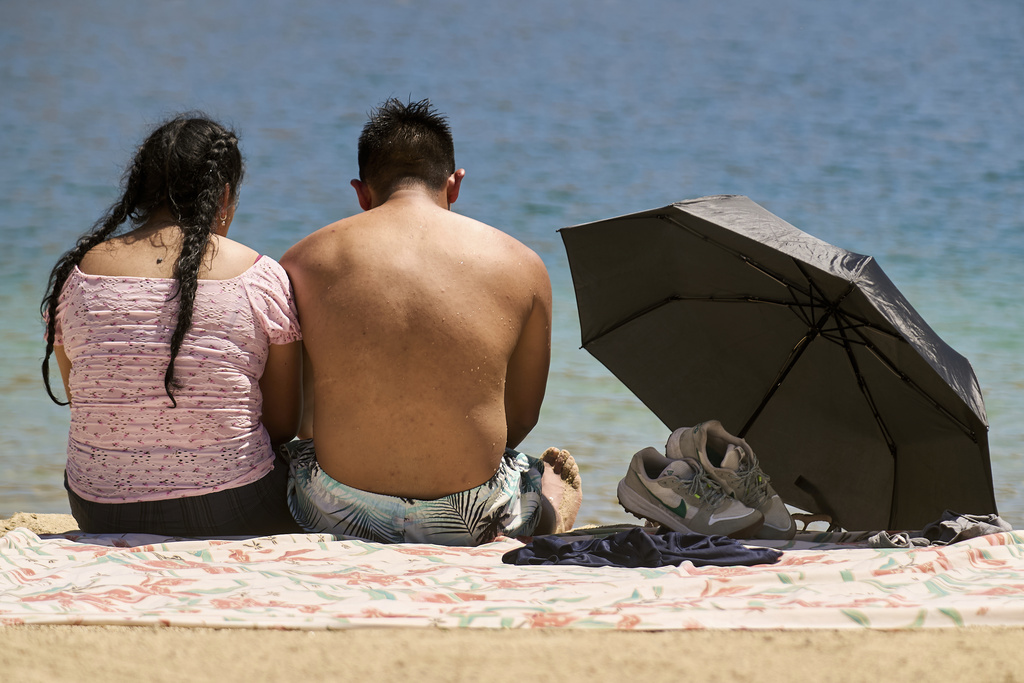 A couple cools off at Castaic Lake as temperatures rise on Wednesday, Aug. 20, 2025, in Castaic, Calif. (AP Photo/Damian Dovarganes)