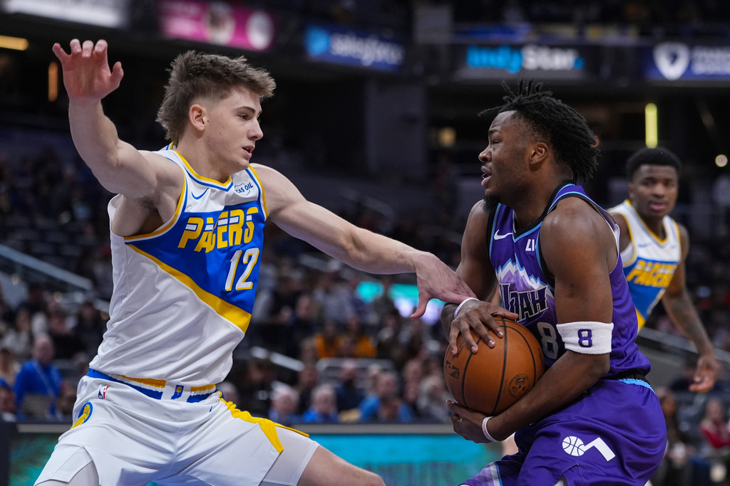 Indiana Pacers guard Johnny Furphy (12) defends Utah Jazz guard Isaiah Collier (8) during the second half of an NBA basketball game in Indianapolis, Tuesday, Feb. 3, 2026. (AP Photo/Michael Conroy)
