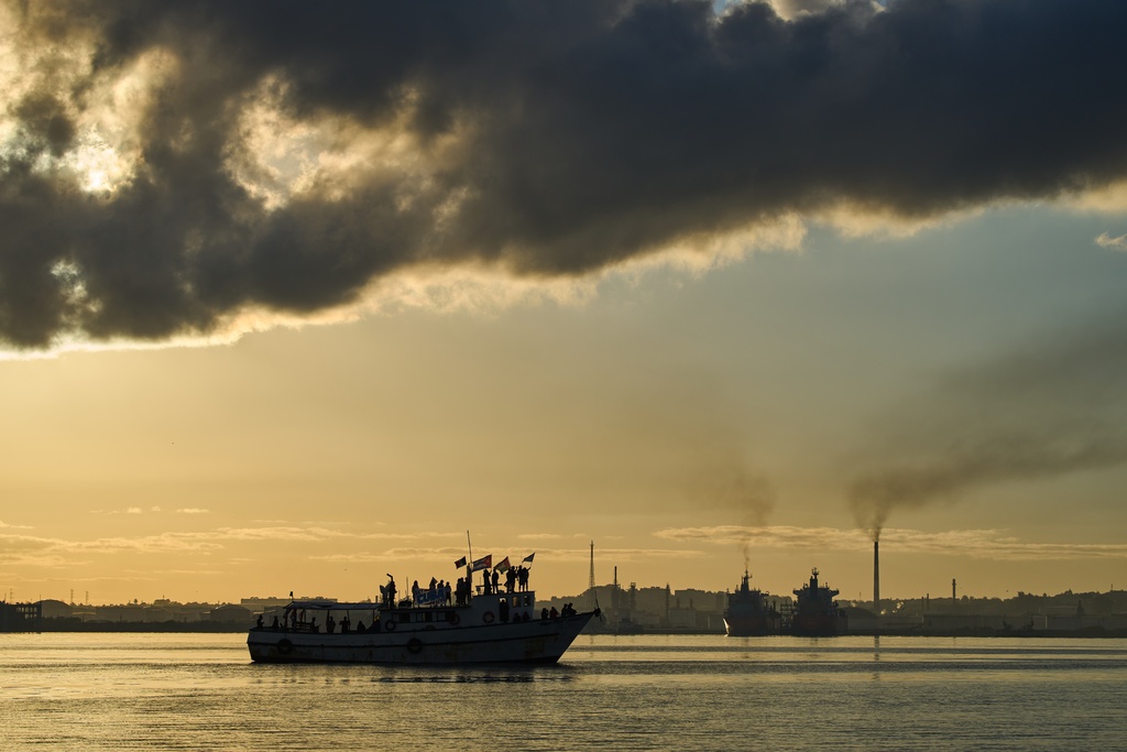 Activists wave Cuban and Palestinian flags from the vessel Maguro, arriving from Mexico with humanitarian aid as part of the "Nuestra America," or Our America convoy, in Havana Bay, Cuba, Tuesday, March 24, 2026. (AP Photo/Ramon Espinosa)