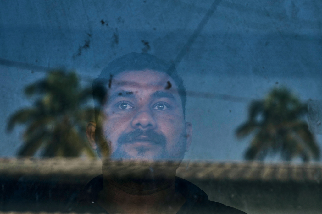 Safeer Mohammed Koorimannil, who was trafficked into scamming, looks out from the window of his CM Fisheries office before starting the day, in Sulthan Bathery in the southern state of Kerala, India, Thursday, March 12, 2026. (AP Photo/Manish Swarup)