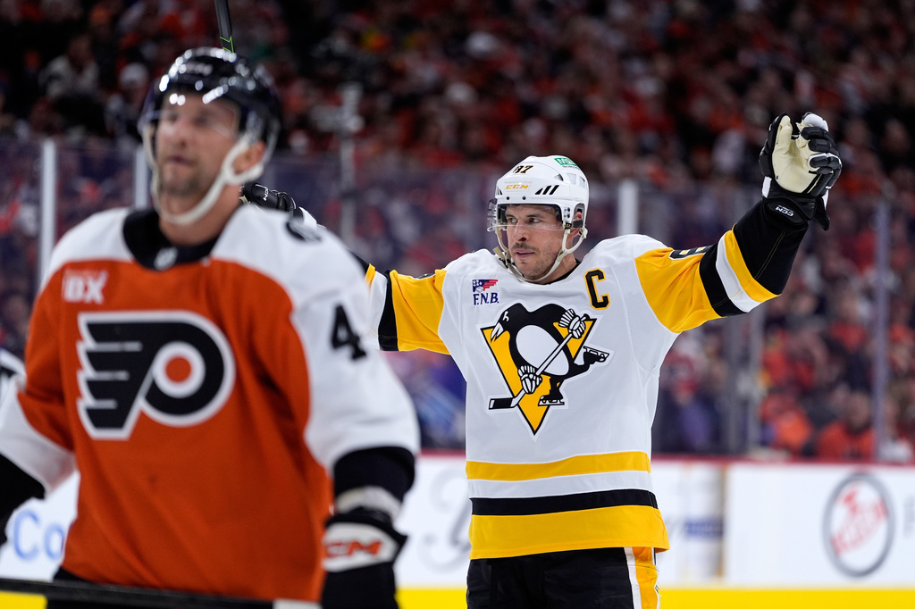 Pittsburgh Penguins' Sidney Crosby, right, reacts behind Philadelphia Flyers' Luke Glendening after scoring during the first period of Game 4 in the first round of the NHL Stanley Cup hockey playoff series Saturday, April 25, 2026, in Philadelphia. (AP Photo/Matt Slocum)