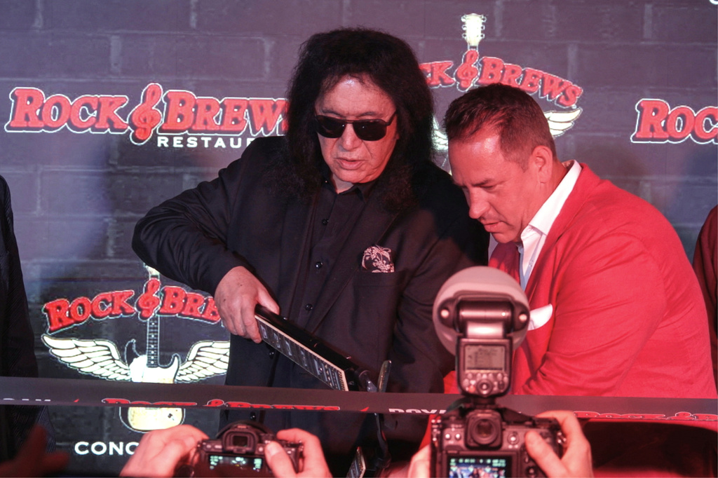 In this image taken from video, KISS frontman Gene Simmons appears with co-franchise owner Danny Yezbick at a ribbon cutting ceremony for Rock & Brews restaurant in Royal Oak, Mich., on Thursday, April 9, 2026. (AP Photo/Mike Householder)