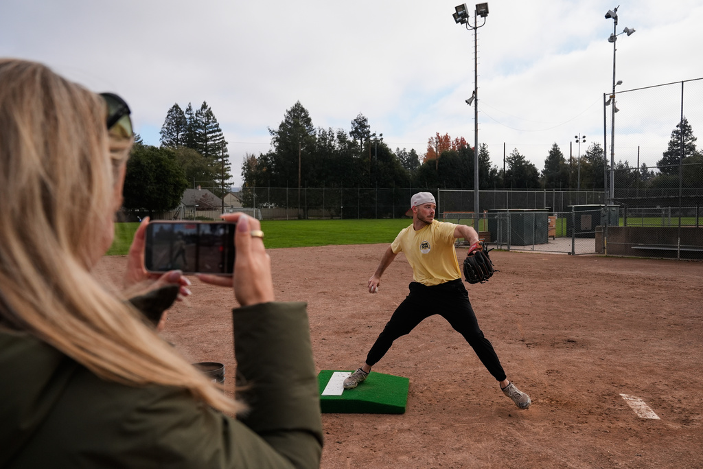 Daulton Jefferies is recorded by his wife Natalie, foreground, as he throws a pitch at Heather Farms Park in Walnut Creek, Calif., Saturday, Dec. 13, 2025. (AP Photo/Godofredo A. Vásquez)