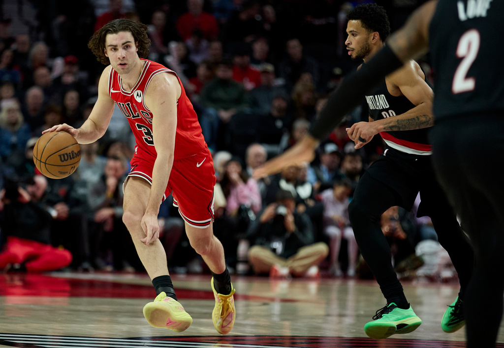 Chicago Bulls guard Josh Giddey, left, dribbles past Portland Trail Blazers forward Toumani Camara during the second half of an NBA basketball game in Portland, Ore., Wednesday, Nov. 19, 2025. (AP Photo/Craig Mitchelldyer)