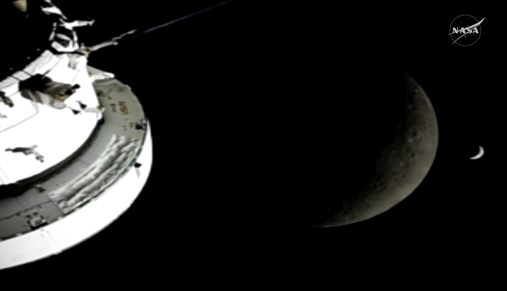 In this image from video provided by NASA, the Orion Spacecraft, the Earth and the Moon are seen from a camera as the Artemis II crew and spacecraft travel farther into Space, Monday, April 6, 2026. (NASA via AP)