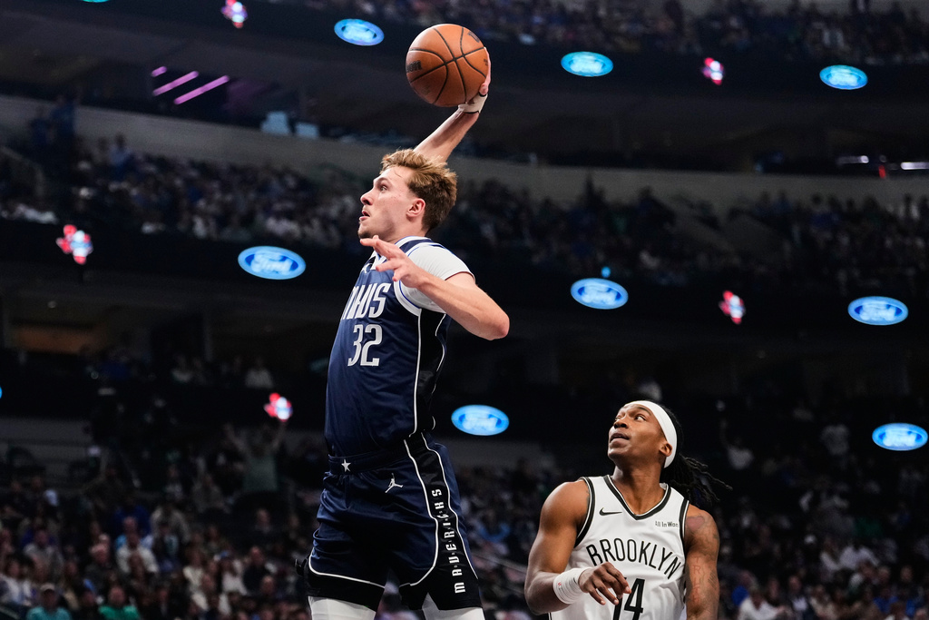 Dallas Mavericks forward Cooper Flagg (32) leaps to the basket to dunk after getting past Brooklyn Nets guard Terance Mann (14) in the first half of an NBA basketball game in Dallas, Friday, Dec. 12, 2025. (AP Photo/Tony Gutierrez)