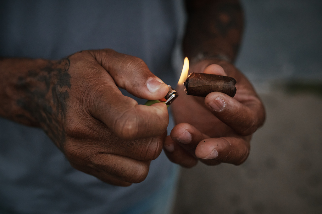 A man lights a cigar outside the grandstand at Aqueduct Racetrack in the Queens borough of New York, Saturday, June 27, 2026. (AP Photo/Andres Kudacki)