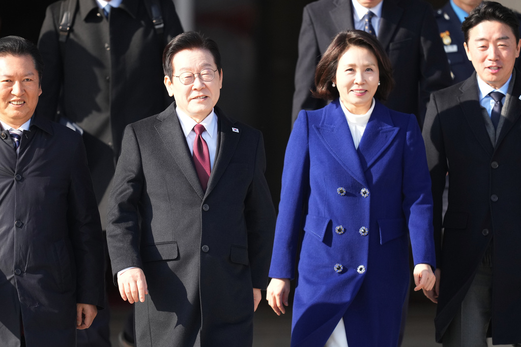 South Korean President Lee Jae Myung, center left, and his wife Kim Hea Kyung arrive to depart for China at the Seoul airport in Seongnam, South Korea, Sunday, Jan. 4, 2026. (AP Photo/Lee Jin-man)