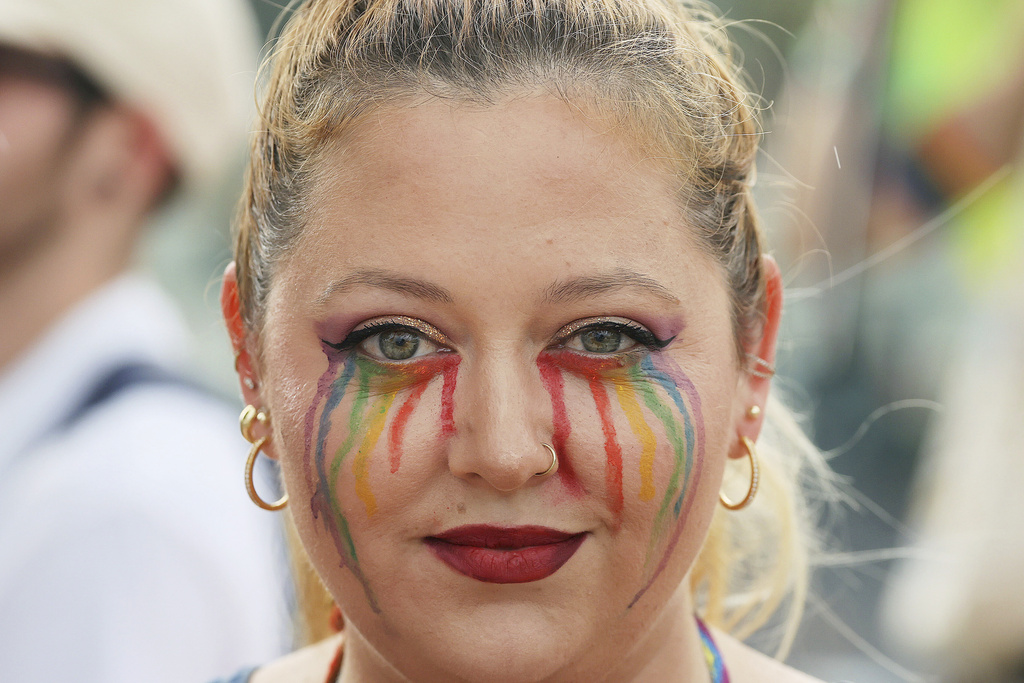 A demonstrator has "rainbow tears" painted on her face during a protest at a crosswalk that was repainted by the Florida Department of Transportation in front of the former PULSE nightclub in Orlando, Fla., Thursday, Aug. 21, 2025. (Stephen M. Dowell/Orlando Sentinel via AP)