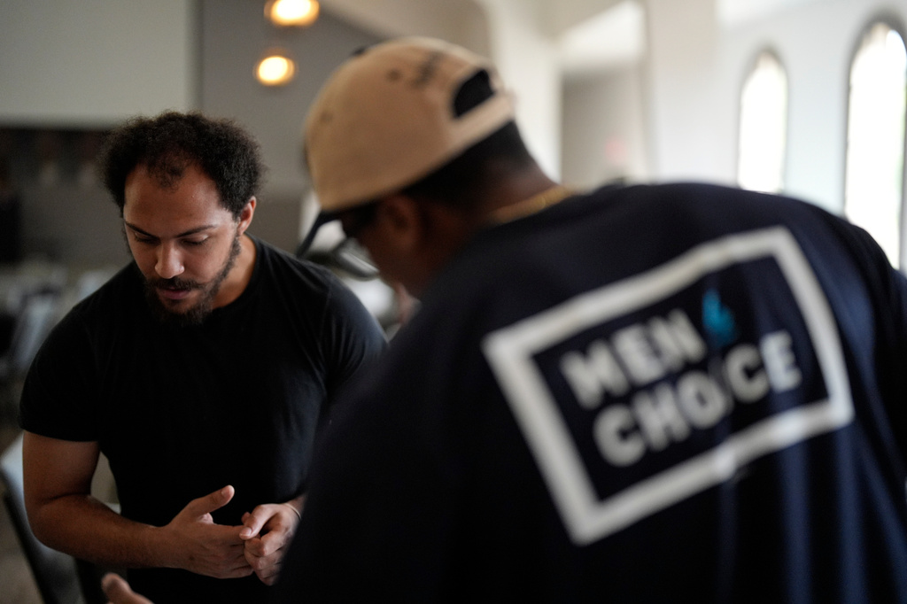 Jeremiah Simmons looks over information at the Men 4 Choice table at Bridgepointe Church during an event, Wednesday, Sept. 16, 2026, in Marietta, Ga. (AP Photo/Mike Stewart)