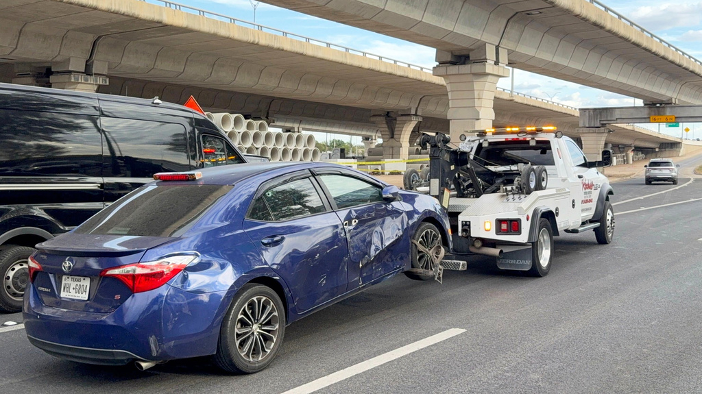 In this photo taken with a smart phone Police move a car from the area where an ICE officer shot a man in Austin, Texas, Sunday, Sept. 20, 2026. (AP Photo/Jesse Bedayn)