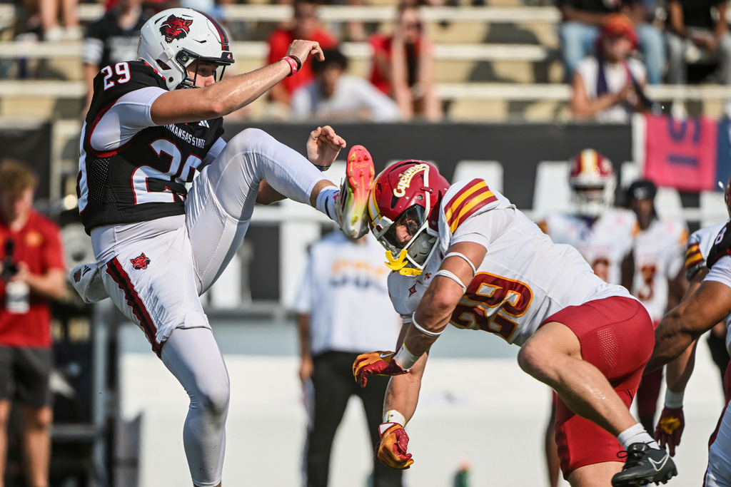 Iowa State defensive back Drew Surges, right, runs into Arkansas State punter Jackson Waller, left, as he is called for a roughing the kicker penalty, during an NCAA college football game Saturday, Sept. 13, 2025, in Jonesboro, Ark. (AP Photo/Michael Woods)