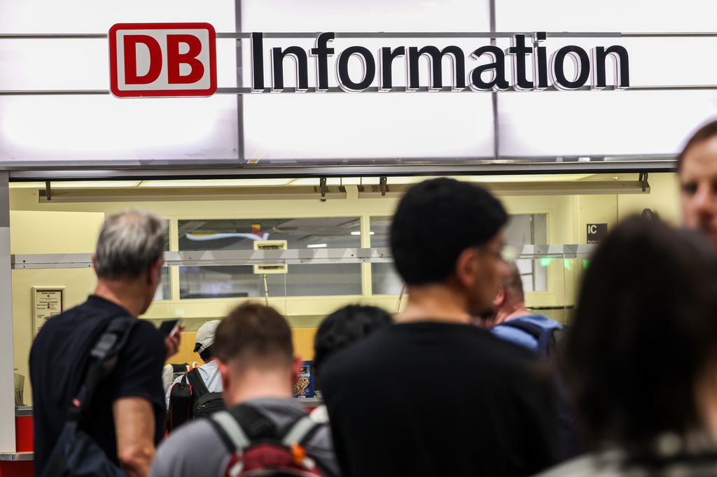 Passengers line up at the DB information desk at the Duisburg train station, Tuesday, June 23, 2026, (Christoph Reichwein/dpa via AP)