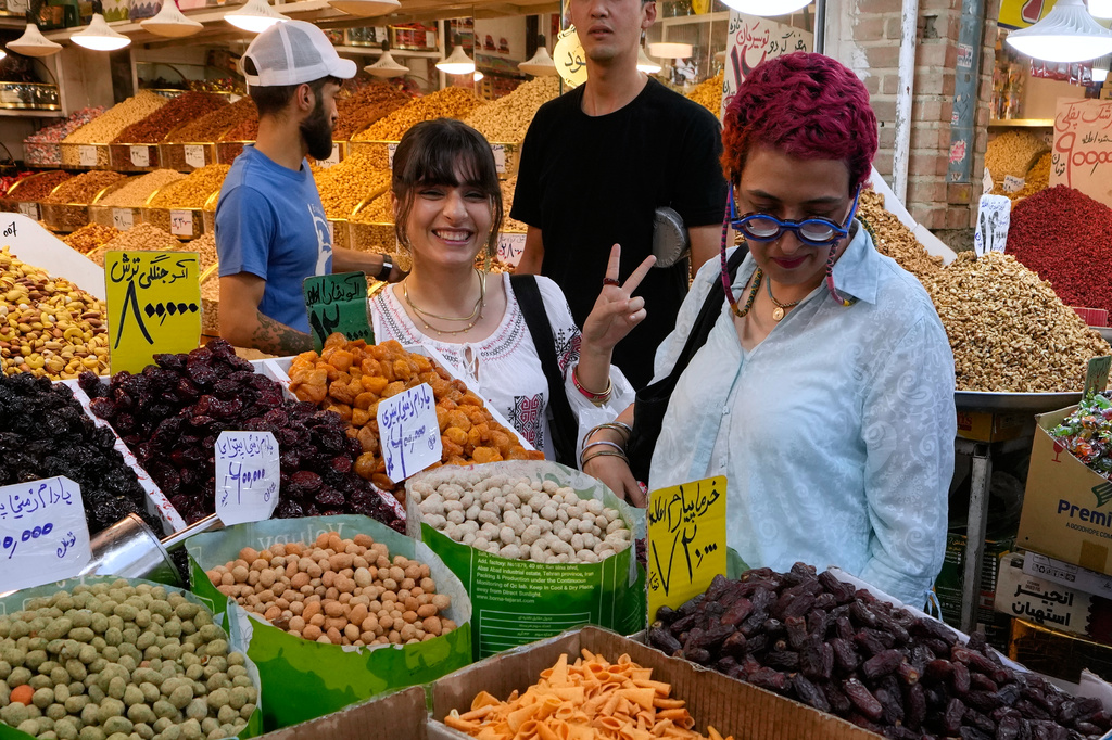 A woman flashes a victory sign while shopping at Tehran's Grand Bazaar in Tehran, Iran, Tuesday, Aug. 25, 2026. (AP Photo/Vahid Salemi)