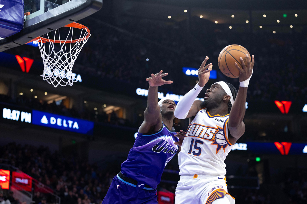 Phoenix Suns center Mark Williams (15) looks to shoot over Utah Jazz forward Taylor Hendricks, left, during the first half of an NBA basketball game, Monday, Oct. 27, 2025, in Salt Lake City. (AP Photo/Anna Fuder)