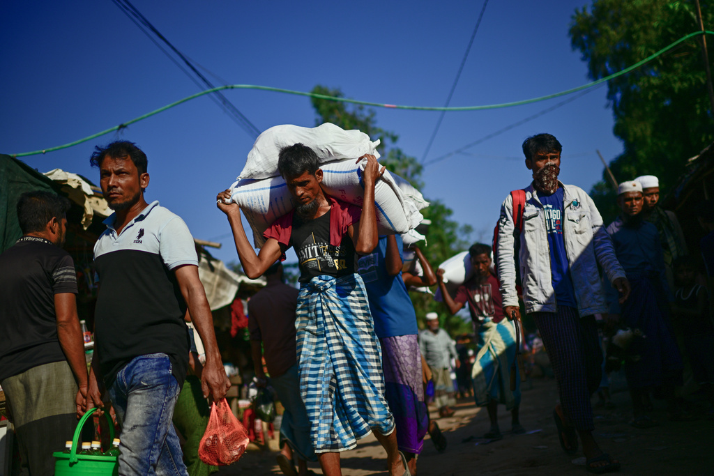 Rohingya refugees carry food rations inside the Rohingya refugee camp in Cox's Bazar, Bangladesh, Monday, Nov. 24, 2025. (AP Photo/Mahmud Hossain Opu)