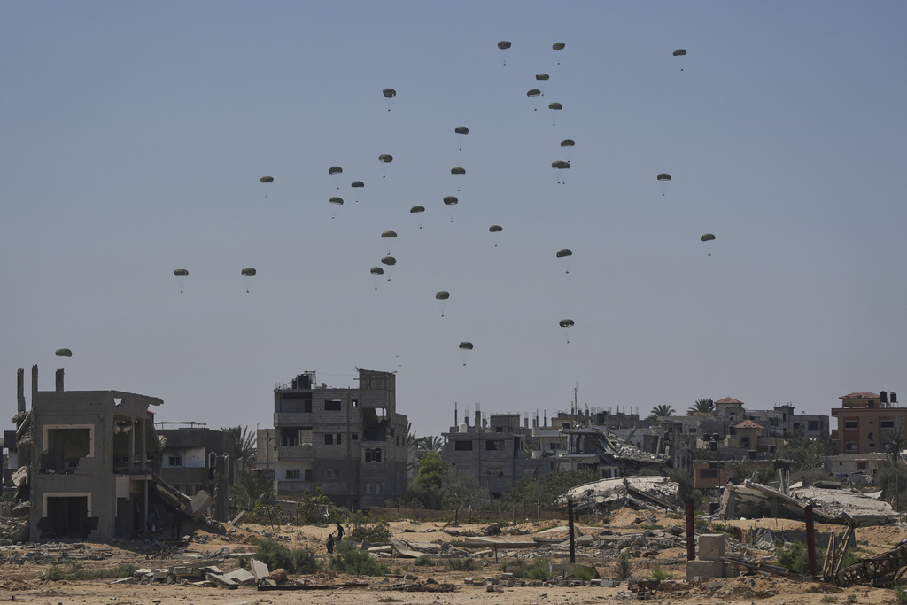 Parachutes drop supplies into Nuseirat, in the central Gaza Strip, Wednesday, Aug. 20, 2025. (AP Photo/Abdel Kareem Hana)