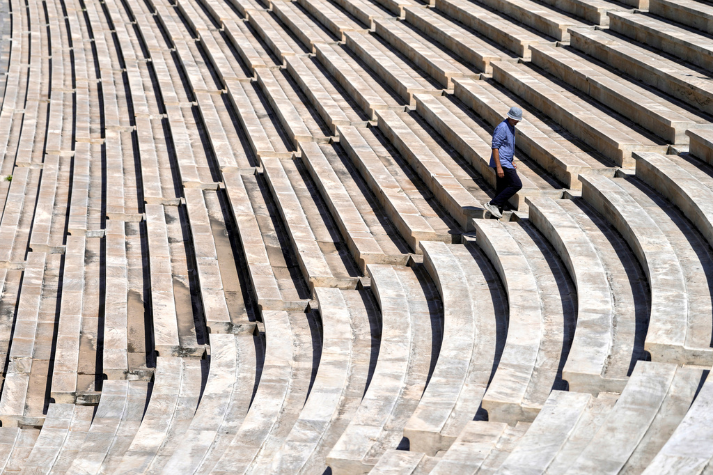 Dimitris Selimis, a senior conservator at the site, inspects the cleaned marble surfaces of the Panathenaic Stadium, also known as "Kallimarmaro," or beautiful marble, which hosted the first modern Olympic Games in 1896, during renovation work in Athens, Greece, Thursday, Aug. 13, 2026. (AP Photo/Thanassis Stavrakis)