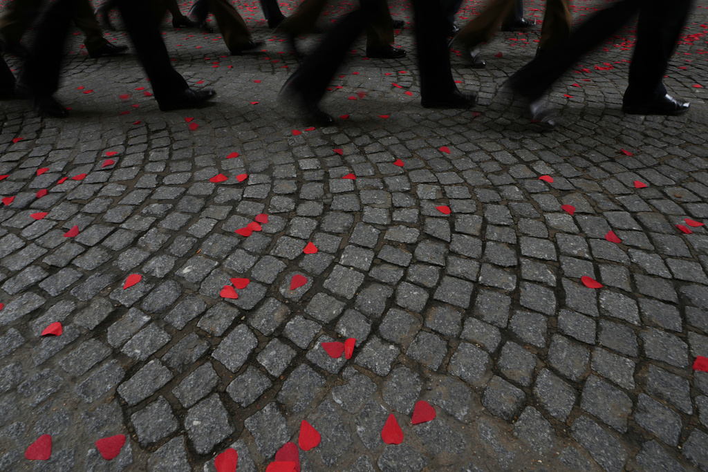 Members of the military march over cobblestones strewn with red paper poppies during an Armistice Day ceremony at the Menin Gate Memorial to the Missing in Ypres, Belgium, Tuesday, Nov. 11, 2025. (AP Photo/Virginia Mayo)