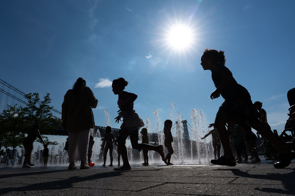 FILE - People play in the fountains by the East River during a heat advisory, in the Brooklyn Borough of New York, May 19, 2026. (AP Photo/Adam Gray, File)