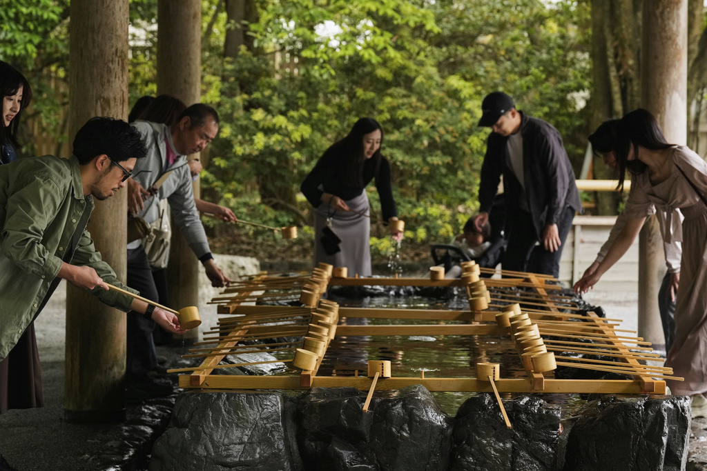 Visitors wash their hands to purify themselves as they visit the Ise Jingu shrine complex in Ise, central Japan, Thursday, May 1, 2025. (AP Photo/Hiro Komae)