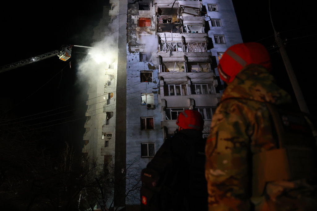 Rescue workers try to put out a fire of a residential building burning after a Russian drone attack on Zaporizhzhia, Ukraine, Tuesday, March 24, 2026. (AP Photo/Kateryna Klochko)