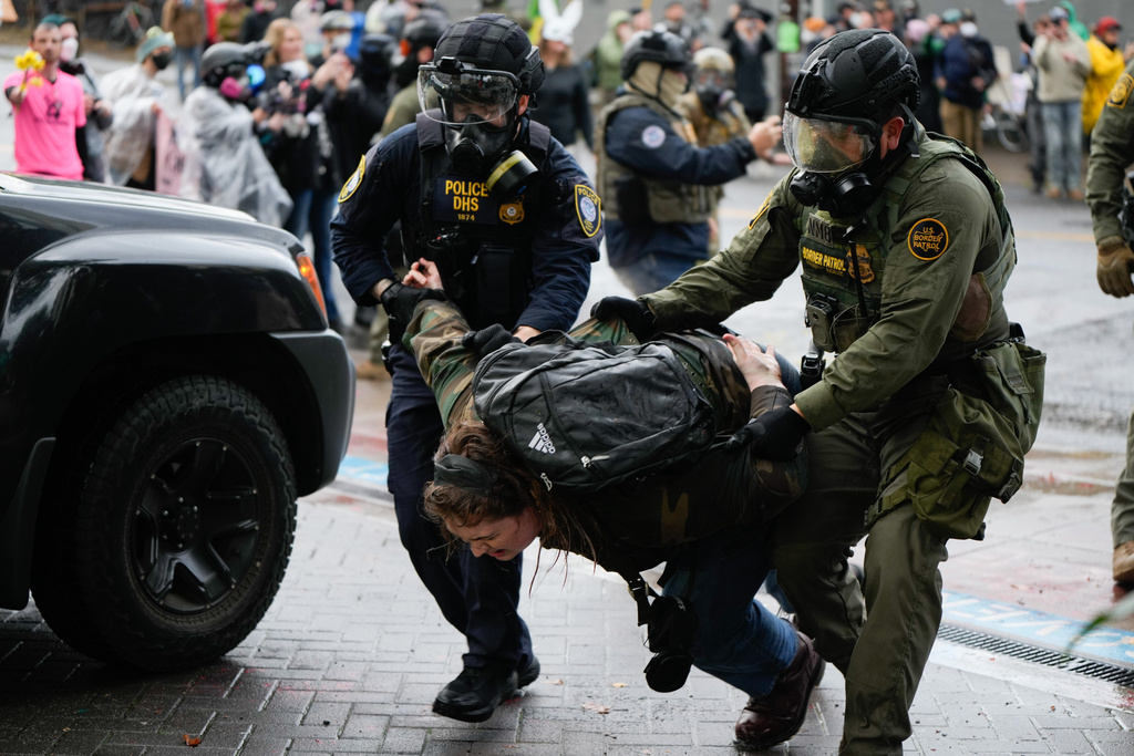 FILE - A protester is detained outside the U.S. Immigration and Customs Enforcement facility on Sunday, Oct. 12, 2025, in Portland, Ore. (AP Photo/Jenny Kane, File)