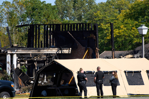 Investigators walk in front of The Church of Jesus Christ of Latter-day Saints in Grand Blanc Township, Mich. where Sunday morning a man rammed his vehicle into the building before opening fire and setting the building ablaze, Tuesday, Sept. 30, 2025. (AP Photo/Ryan Sun) Investigators walk in front of The Church of Jesus Christ of Latter-day Saints in Grand Blanc Township, Mich. where Sunday morning a man rammed his vehicle into the building before opening fire and setting the building ablaze, Tuesday, Sept. 30, 2025. (AP Photo/Ryan Sun)