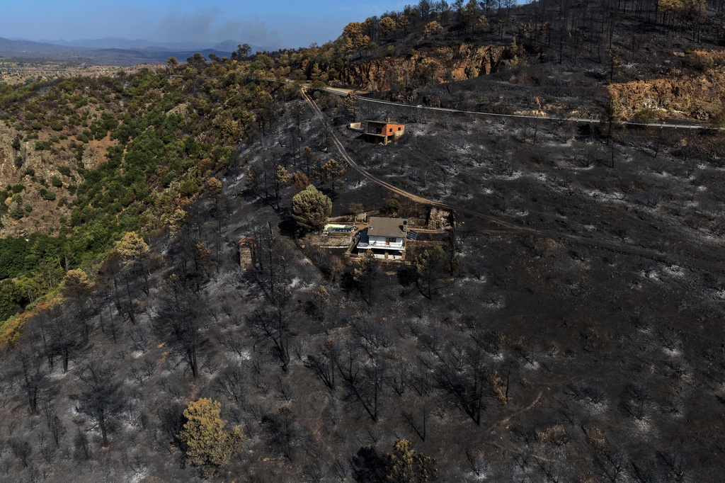 FILE - An area scorched by a wildfire surrounds structures in El Tiemblo, Avila province, Spain, Thursday, July 30, 2026. (AP Photo/Manu Fernandez, File)