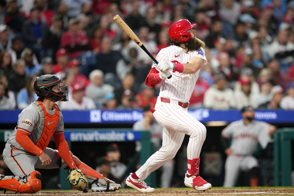 Philadelphia Phillies' Brandon Marsh, right, follows through after hitting an RBI-sacrifice fly against San Francisco Giants pitcher Tyler Mahle during the fourth inning of a baseball game Tuesday, April 28, 2026, in Philadelphia. (AP Photo/Matt Slocum)