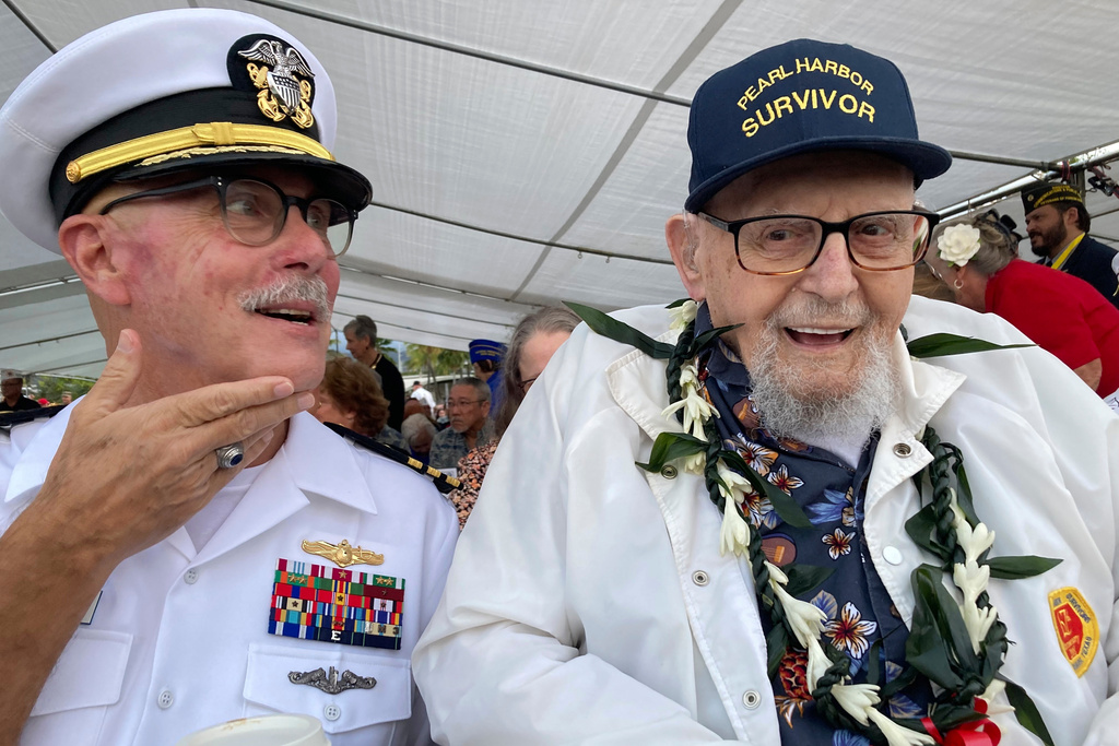 FILE - Ira Schab, right, who survived the attack on Pearl Harbor as a sailor on the USS Dobbin, talks with reporters while sitting next to his son, retired Navy Cmdr. Karl Schab, on Dec. 7, 2022, in Pearl Harbor, Hawaii. (AP Photo/Audrey McAvoy, File)