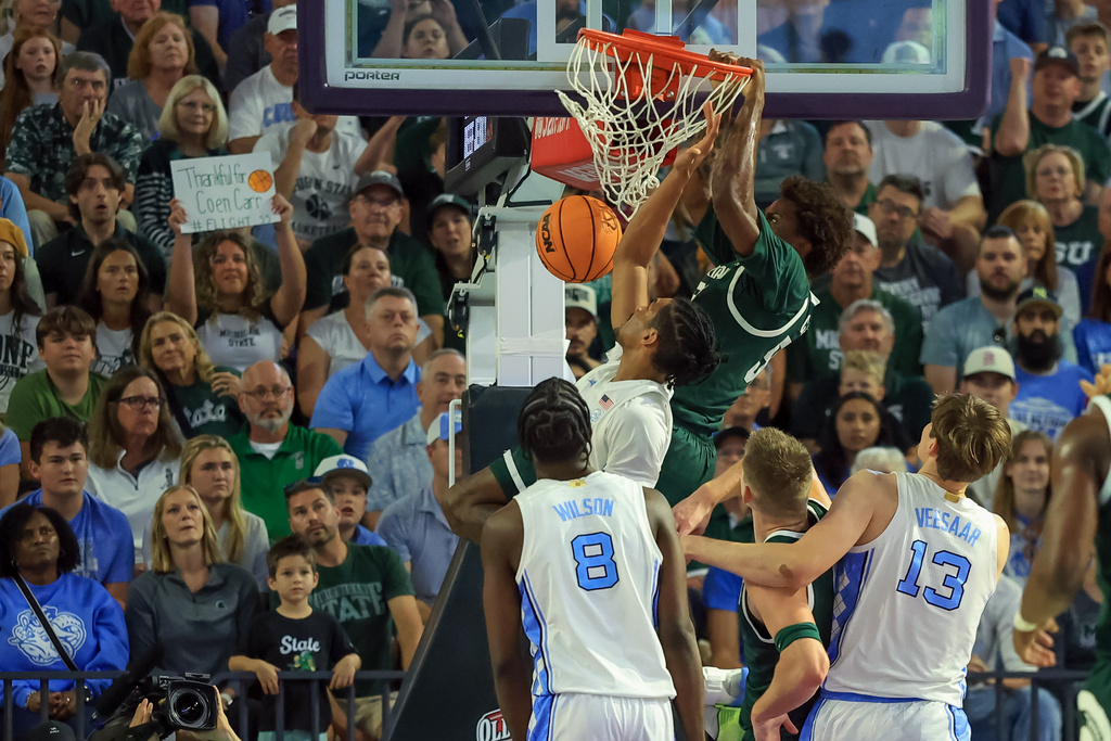 Michigan State forward Coen Carr, top, dunks against North Carolina during the first half of an NCAA college basketball game Thursday, Nov. 27, 2025, in Fort Myers, Fla. (AP Photo/Mike Carlson)