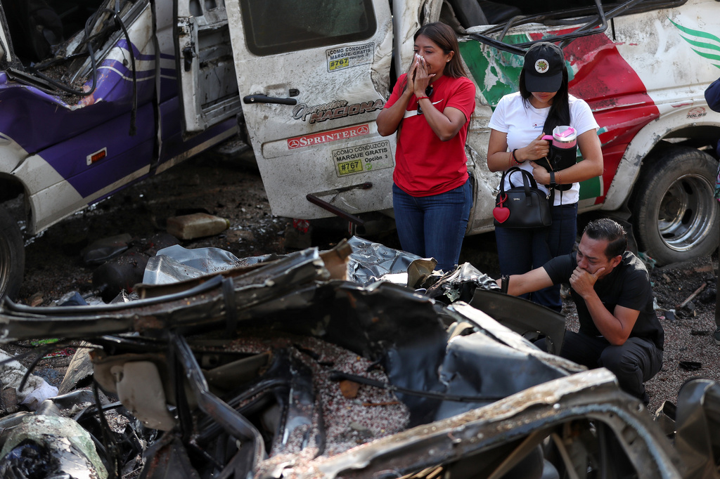 Relatives of victims pay respects at the site of an attack on the Pan-American Highway in Cajibio, Colombia, Sunday, April 26, 2026, where at least a dozen people were killed in an attack authorities blamed on dissident groups of the former FARC rebels. (AP Photo/Santiago Saldarriaga)