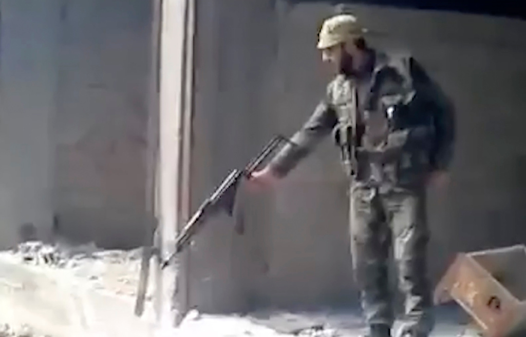 FILE - This frame grab from a 2013 video, shows a Syrian soldier firing into a large pit full of bodies, in the Tadamon neighborhood of Damascus, Syria. (AP Photo, File)