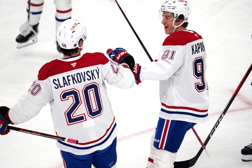Montréal Canadiens' Oliver Kapanen, right, celebrates with Juraj Slafkovský (20) after scoring during the first period of an NHL hockey game against the Pittsburgh Penguins in Pittsburgh, Sunday, Dec. 21, 2025. (AP Photo/Gene J. Puskar)