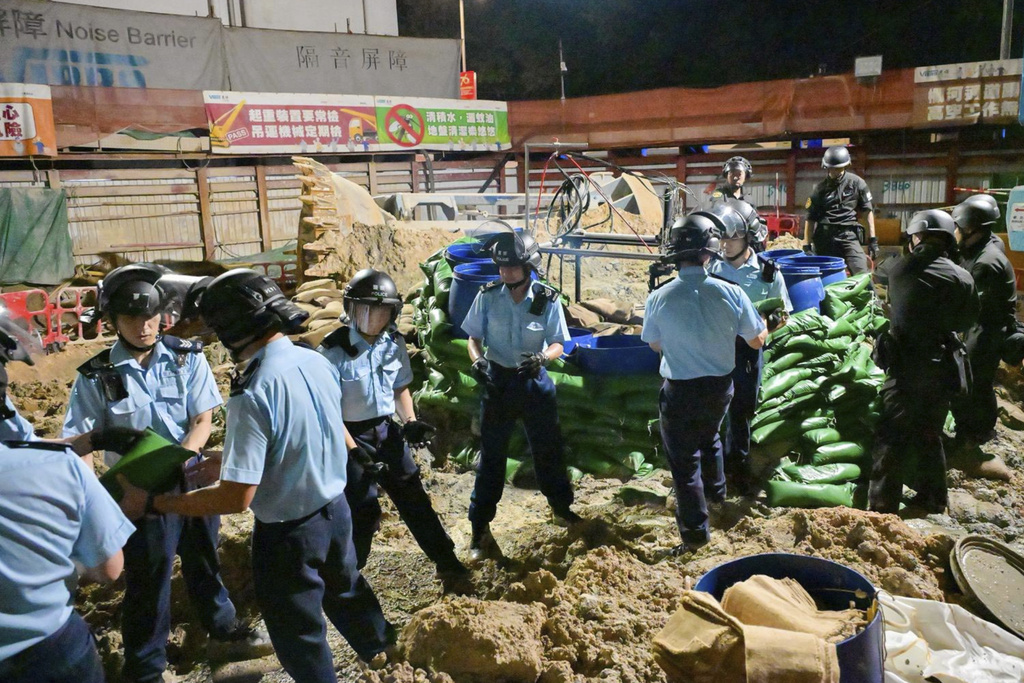 In this photo taken in the early hours of Sept. 20. 2025 and released by Hong Kong Police, police officers prepare to defuse a large U.S.-made bomb left over from World War II that was discovered at a construction site in Hong Kong. (Hong Kong Police via AP)