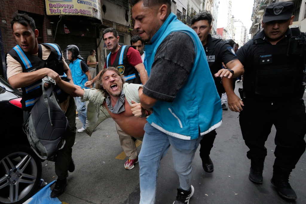 Police detain a protester during a march by trade unions and opposition groups protesting a labor reform bill proposed by President Javier Milei's government in Buenos Aires, Argentina, Wednesday, Feb. 11, 2026. (AP Photo/Gustavo Garello)