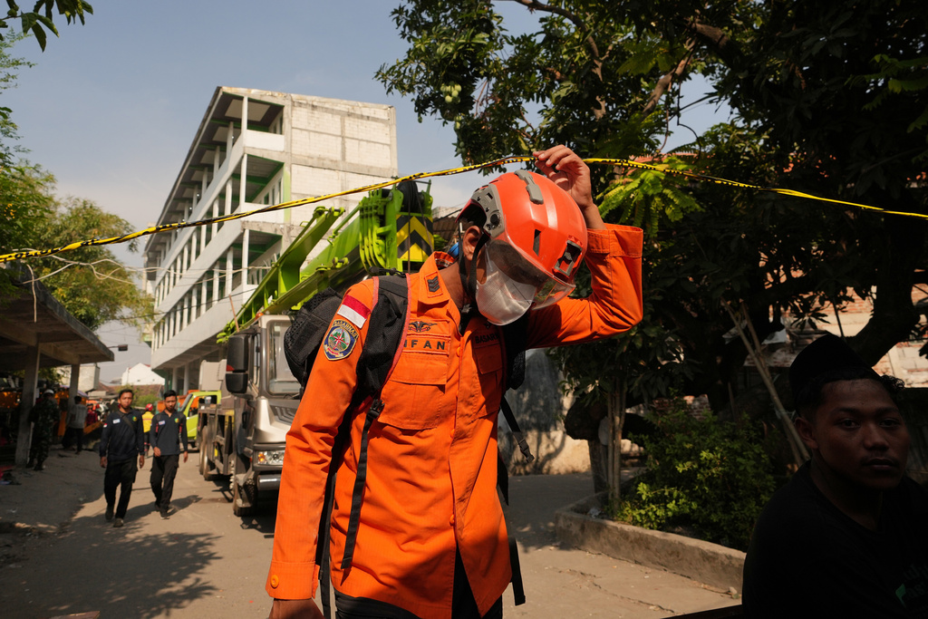 A rescuer walks near the islamic boarding school where a building collapsed in Sidoarjo, East Java, Indonesia, Saturday, Oct. 4, 2025. (AP Photo/Achmad Ibrahim)