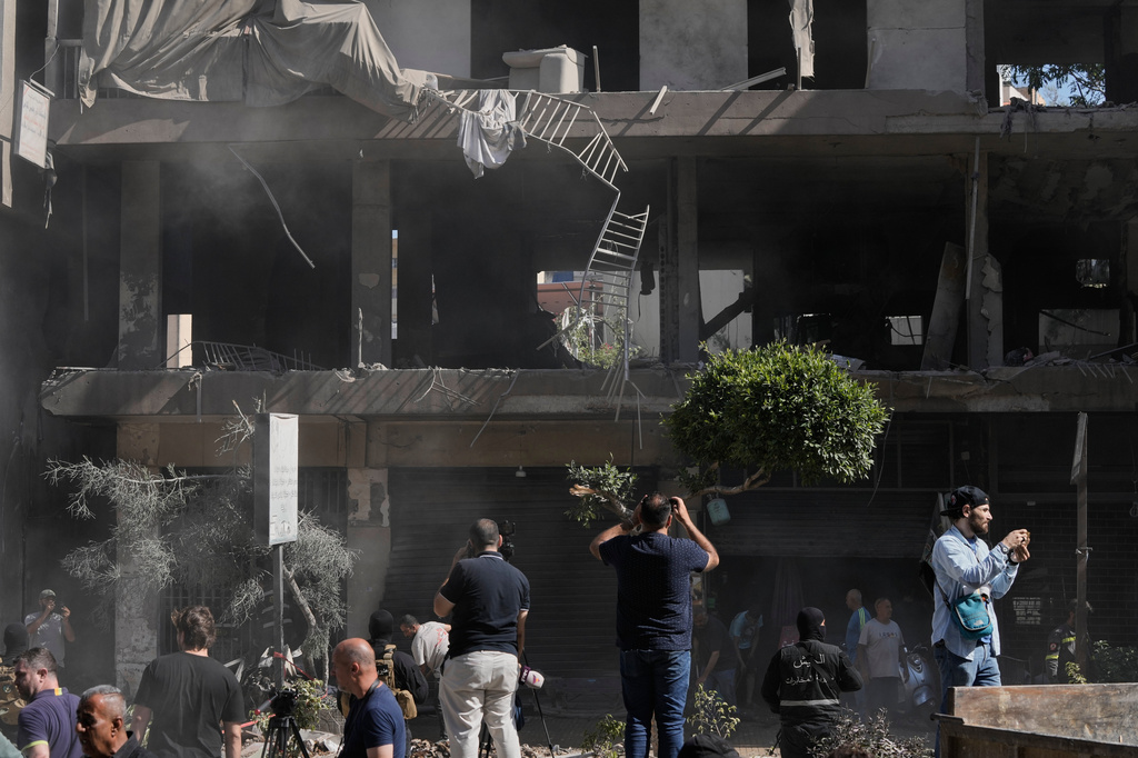 People gather at the site of an Israeli airstrike that struck an apartment in Dahiyeh, Beirut's southern suburbs, Lebanon, Sunday, June 14, 2026. (AP Photo/Bilal Hussein)